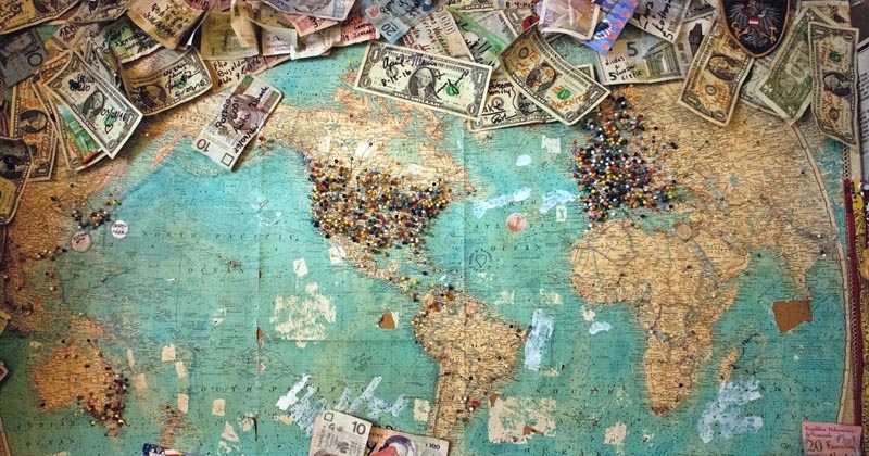 Map of the world with location pins and money.